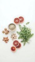 Healthy superfood ingredients with grapefruit slices, quinoa, nuts and arugula leaves arranged on white background for clean eating and nutrition.
