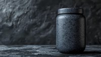 Black matte container with water drops on dark background, minimalist product photography with dramatic lighting and condensation texture for cosmetic packaging.
