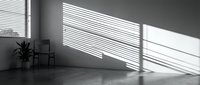 Minimalist interior room with dramatic sunlight streaming through venetian blinds creating striped shadow patterns on white wall and floor.