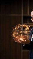Professional businessman holding glowing digital sphere with business strategy icons and data analytics symbols for corporate planning and growth concepts.