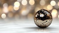 Decorative metal sphere with intricate floral cutout pattern casting delicate shadows on light surface against blurred golden bokeh background.