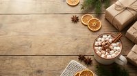 Overhead view of rustic wooden surface with wrapped kraft gift boxes, mug of hot cocoa with marshmallows, dried citrus slices, star anise, and evergreen sprigs for holiday seasonal marketing.