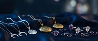 Elegant jewelry collection with gold and silver necklaces, earrings and pendants displayed on dark fabric surface for luxury fashion accessories.