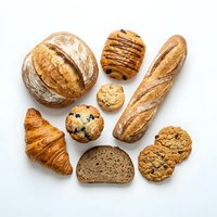 Assorted fresh baked goods including artisan bread, croissants, and cookies arranged on white background. Bakery products for food and culinary design.