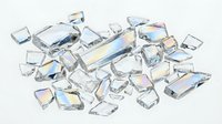 Scattered collection of clear and iridescent crystal gemstones and faceted glass stones isolated on white background, suitable for jewelry design, craft projects, and decorative applications.