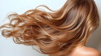 Flowing caramel blonde hair with honey highlights waves in motion against neutral background, showing natural shine and healthy texture for beauty and haircare advertising.