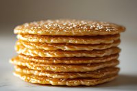 Stack of golden homemade pancakes with honey or maple syrup dripping down sides, close-up macro shot showing fluffy texture and layers on neutral background.