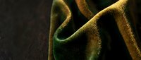 Luxurious golden silk fabric with elegant folds and soft lighting creating dramatic shadows and highlights for premium textile and fashion design projects.