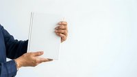 Mature man with medium skin tone holding blank white card and laptop, representing business communication, customer service, or digital marketing concepts.