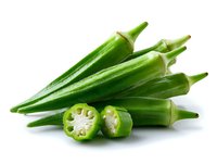Fresh green okra pods and sliced cross sections showing inner texture and seeds on white background, isolated healthy vegetable ingredient for cooking.