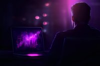 Silhouette of businessman working late at laptop with glowing purple screen and bokeh lights, creating mysterious cybersecurity atmosphere.