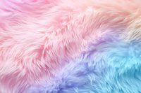 Soft pastel rainbow faux fur texture with pink, purple and blue gradient colors creating dreamy fluffy background for creative design projects.