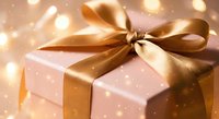 Elegant gift box with golden ribbon bow and warm bokeh lights creating festive atmosphere for holidays, celebrations, birthdays, and special occasions.