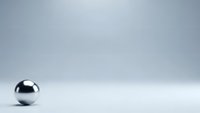 Metallic chrome sphere on clean white surface with soft gray gradient background for modern minimalist design projects.