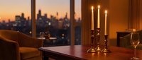 Elegant candlelit evening interior with city skyline view through windows, warm ambient lighting creating romantic atmosphere for dining or relaxation.