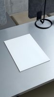 Blank white paper sheet on modern office desk with lamp for business presentations and corporate documentation mockup.