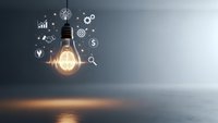 Glowing light bulb with business icons representing innovation, creativity, and entrepreneurship concepts for startup and technology solutions.