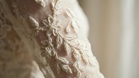 Elegant ivory lace fabric with intricate floral embroidery and delicate beadwork detail for luxury wedding dress or bridal fashion design projects.