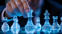 Glass chess pieces on board with dramatic blue lighting and hand moving queen piece, creating strategic business concept atmosphere for leadership and decision making.