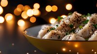 Asian dumplings with sesame seeds and herbs in golden bowl against warm bokeh lights background for festive dining and culinary presentations.