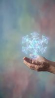 Human hand holding glowing geometric crystal structure with holographic light effects on colorful gradient background for technology and innovation concepts.