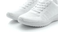 White knit sneakers with laces on a light background, showcasing modern athletic footwear design for sport and casual lifestyle use.