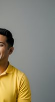 Young Asian male wearing bright yellow polo shirt, smiling in profile against neutral gray background, suitable for business, lifestyle, and corporate marketing materials.