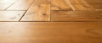 Natural hardwood flooring planks with warm golden brown tones and visible wood grain texture for interior design and home renovation projects.