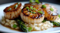 Pan-seared sea scallops with caramelized glaze served on creamy risotto and garnished with fresh asparagus tips and green onions in savory sauce.