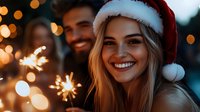 Young woman in Santa hat smiling with sparkler at Christmas celebration, warm bokeh lights background creating festive atmosphere. Joyful holiday moment.