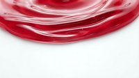 Red liquid swirl with flowing motion creating dynamic waves and curves on white background for creative design projects.