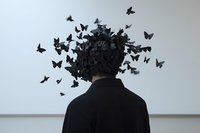 Man in black with head dissolving into swarm of dark butterflies, surreal concept of mental chaos, freedom, transformation, and inner thoughts.
