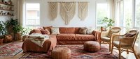 Cozy boho living room with terracotta sectional sofa, macrame wall art, wicker furniture and colorful rug creating warm modern interior design space.