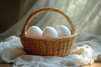 Fresh white eggs in rustic woven basket on soft white fabric with gentle natural sunlight streaming through window, creating warm morning atmosphere.