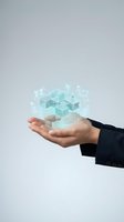 Businessperson holding glowing holographic building structure with digital interface elements, representing real estate technology, property management, and architectural innovation for commercial use.