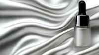 Frosted glass dropper bottle on luxurious white silk fabric with elegant folds and waves creating soft shadows. Premium skincare and cosmetic product presentation.