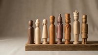 Wooden peg dolls in various natural finishes and colors arranged in a row on a wooden base, suitable for toy design, craft projects, and educational materials.