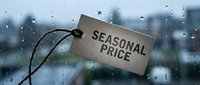 Seasonal price tag hanging against a rainy window with blurred urban background, concept of weather-based pricing and sales promotions.