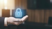 Businessman hand holding glowing padlock hologram symbol representing data security, cybersecurity protection, and digital safety solutions for enterprise networks.