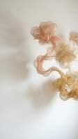 Abstract flowing smoke ribbons in warm peach and golden tones creating elegant swirls against soft neutral background for luxury design projects.