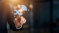 Businessman in suit touching glowing wireless connectivity icon with network signals and bokeh light effects, representing digital communication and internet technology solutions.