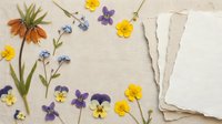 Vintage flat lay with colorful pressed flowers, old paper cards and natural linen background for scrapbooking, crafts and botanical design projects.