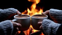Cozy winter evening with two cups of hot chocolate by fireplace, hands in warm knitted sweaters holding ceramic mugs against glowing flames background.