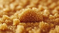 Golden glitter particles with sparkling bokeh effect creating luxurious shimmer texture for festive backgrounds and elegant design projects.