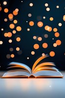 Open book with glowing pages against dark background, magical orange bokeh lights floating upward creating dreamy atmosphere for education and storytelling concepts.