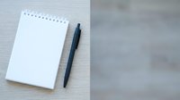 Blank spiral notebook with black pen on white wooden surface, ready for writing, planning, and note-taking projects.