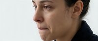 Caucasian woman crying with tears on her cheeks, side profile view, emotional expression of sadness and grief on white background.