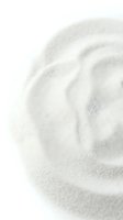 Close-up of fine white sand with rippled texture and soft shadows, suitable for beach, wellness, spa, and nature-themed designs.