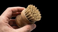 Wooden brush with natural bristles held in hand, isolated on transparent background. Ready for design use on t-shirts, clipart, stickers, print-on-demand products and sublimation projects.