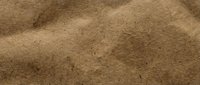 Natural brown sand texture with rippled dunes and wind patterns creating organic waves and shadows for desert landscape backgrounds.